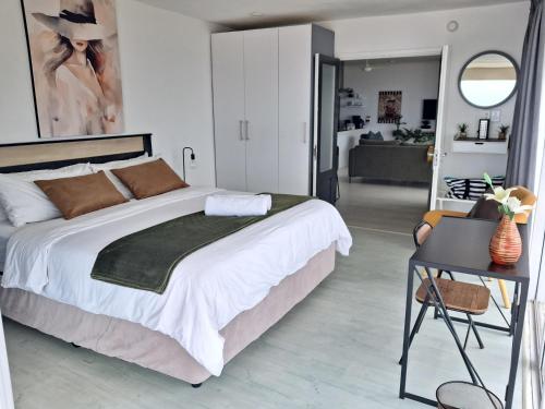 a bedroom with a large bed and a living room at 511 Umdloti Resort 1 bed beachfront Apartment self catering Great Sea View in Umdloti
