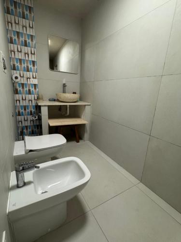 a white bathroom with a sink and a mirror at Il Panorama di Ercole in Monte di Procida
