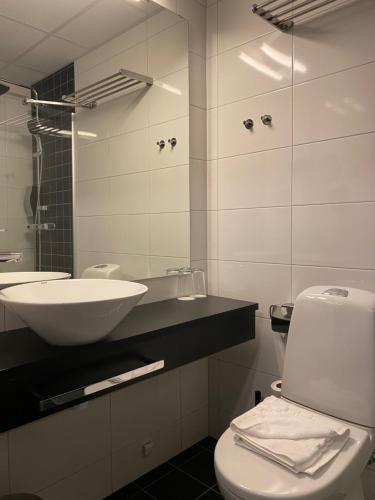 a white bathroom with a sink and a toilet at Hotell Rättvik in Rättvik