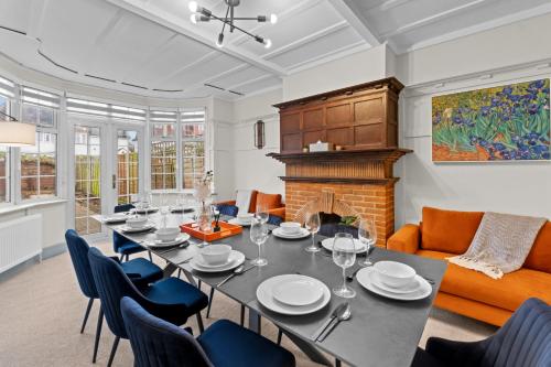 a dining room with a table and chairs and a fireplace at 5 Bedroom House 13 Beds Across From Tube Station in London