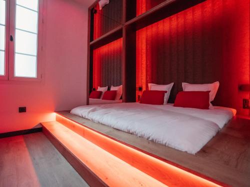 a bedroom with a large bed with red curtains at L'unique - Love-room Romantique in Angoulême