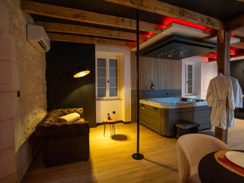 a living room with a couch and a kitchen at L'unique - Love-room Romantique in Angoulême