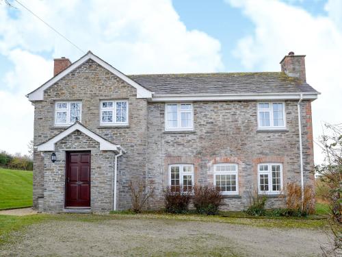 a brick house with a red door at Tregunna Cottage in Wadebridge