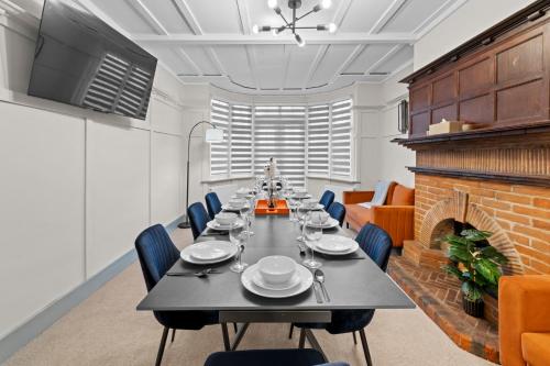 a long table in a room with a fireplace at 5 Bedroom House 13 Beds Across From Tube Station in London