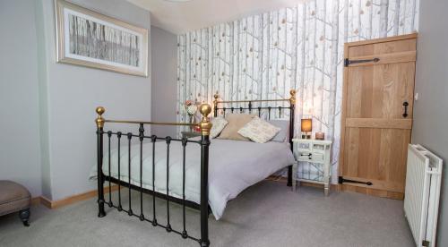 a bedroom with a bed and a wall at Fall in Green in Haworth