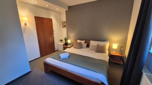 a bedroom with a large bed and two lamps at Penzion Jelínek in Opočno