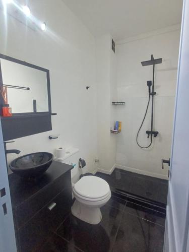 a bathroom with a toilet and a sink and a cross on the wall at San bernardo ll in San Bernardo