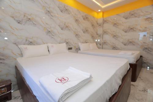two twin beds in a room with marble walls at HOTEL CYRIL in Kanyakumari