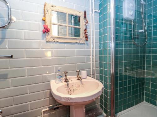 a bathroom with a sink and a shower at Sammy Hakes Cottage in Watchet