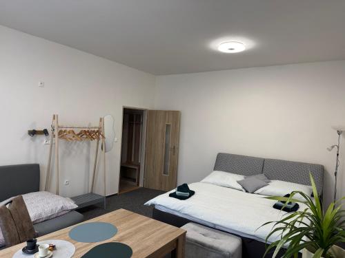 a living room with a bed and a table at Penzion Pollet in Pilsen