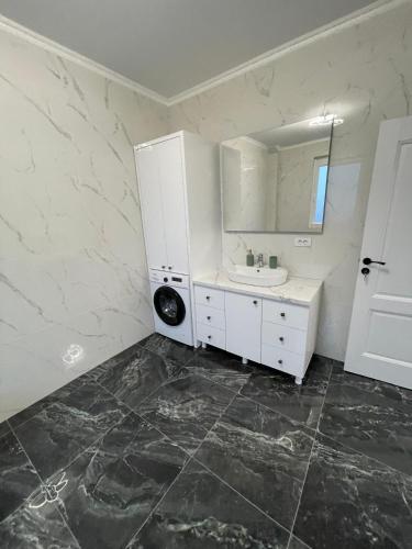 a white bathroom with a sink and a mirror at Rădăuți Residence 3 in Rădăuţi