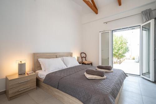 a bedroom with a bed and a large window at Villa Aionia in Lepeda in Lixouri