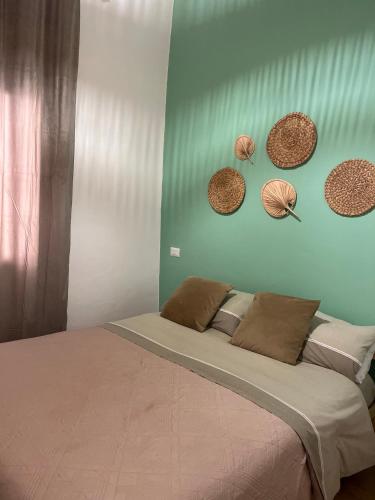 a bedroom with a bed with hats on the wall at Piazzetta Degli Innamorati in Bari