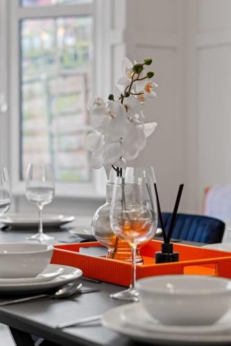 a table with a vase with white flowers in it at 5 Bedroom House 13 Beds Across From Tube Station in London
