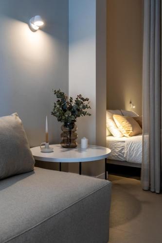a living room with a bed and a table with flowers at Valencia Malvarrosa point beige in Valencia