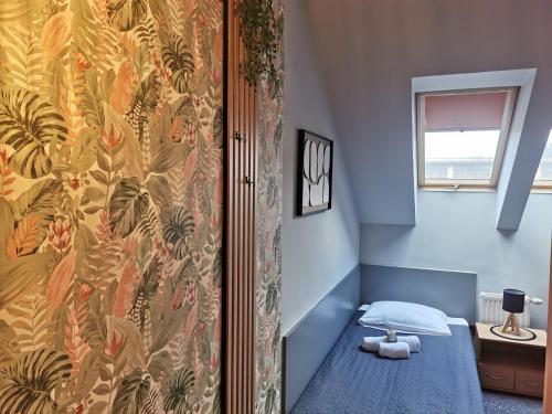 a small room with a bed and a wall at Gościniec nad Olzą in Cieszyn