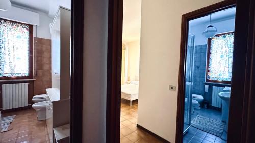a bathroom with a toilet and a glass door at N294 - Numana, ampio quadrilocale con giardino e wifi in Numana