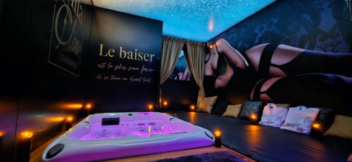a room with a bed with a woman in a black dress at VILLA CLOSE BRIVE centre - LOVE ROOM - SPA privatif in Brive-la-Gaillarde