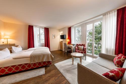a hotel room with two beds and a living room at Hotel Am Schloss *** Superior in Tübingen