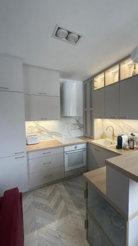 a large kitchen with white counters and white cabinets at Apartament Centrum Ligota in Katowice