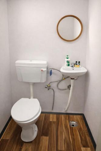 a bathroom with a toilet and a sink at Mud Meadows Peace and Tranquility Farm With Pool in Faridabad