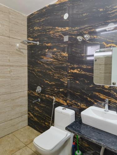 a bathroom with a white toilet and a sink at Stay in peace in Dehradun