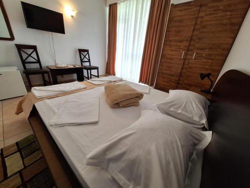 a large bed with white sheets and pillows on it at Hotel Metropol in Mamaia