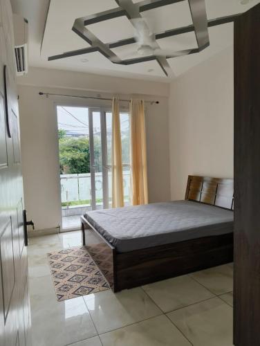 a bedroom with a bed and a large window at Stay in peace in Dehradun