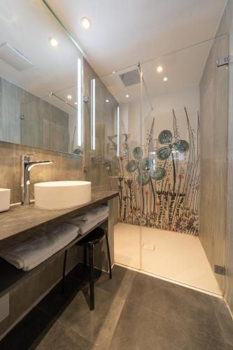 a bathroom with a sink and a large mirror at Hotel Am Schloss *** Superior in Tübingen