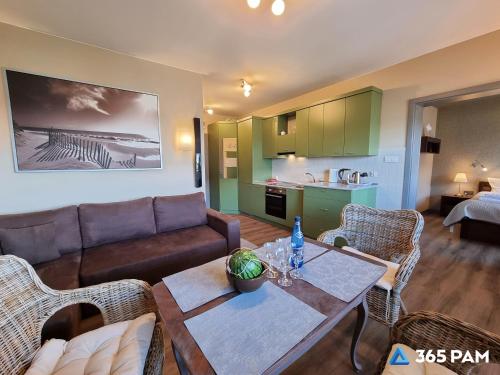 a living room with a couch and a table at 365PAM - Apartament 5 Mórz - BASEN, PLAC ZABAW, PARKING W CENIE in Sianozety