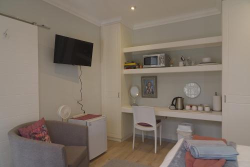 a living room with a couch and a desk with a microwave at Naval Hill Nook in Bloemfontein
