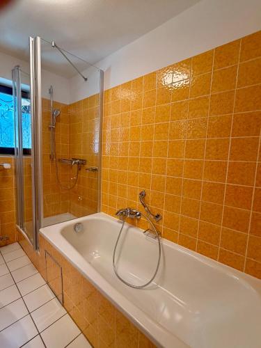 a bath tub in a bathroom with orange tile at FeWo Reserl in Bischofswiesen
