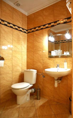 ein Badezimmer mit Toilette und Waschbecken in der Unterkunft Pałac Biedrusko in Posen