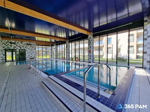 a large swimming pool inside of a building at 365PAM - Apartament 5 Mórz - BASEN, PLAC ZABAW, PARKING W CENIE in Sianozety
