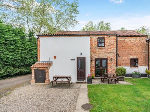 a brick building with a picnic table and benches at Little Barn - 16438 in York