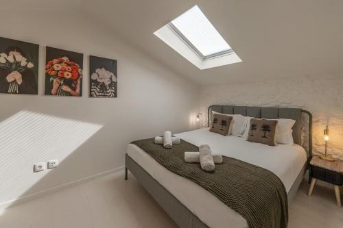 a bedroom with a bed with two towels on it at The Bliss House in Lourinhã