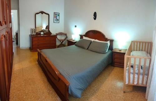 a bedroom with a bed and a mirror and a crib at Casa da Rosa in Sezze