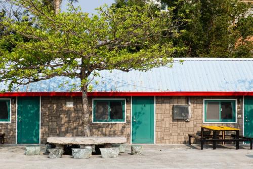 墾丁的住宿－墾丁大尖山原野小屋，一座带野餐桌和树的建筑