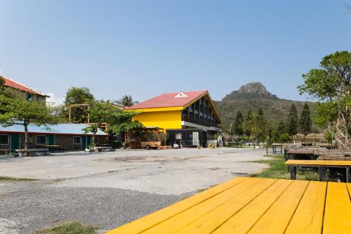 墾丁的住宿－墾丁大尖山原野小屋，黄色的建筑,前面有一张黄色的桌子