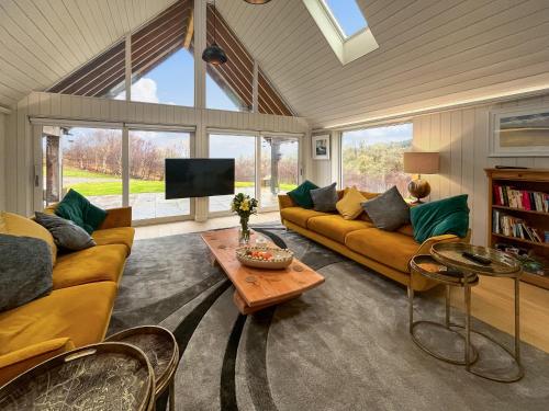 a living room with a couch and a table at Achandoilach House in Strathcarron