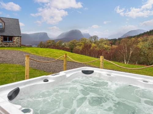 a jacuzzi tub in the backyard of a house at Achandoilach House in Strathcarron