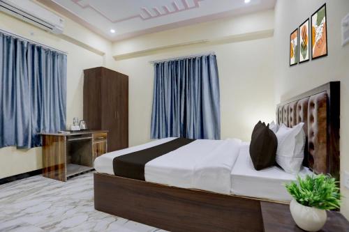 a bedroom with a large bed and a desk at Hotel O by OYO SGD Lawn And Hotel in Varanasi