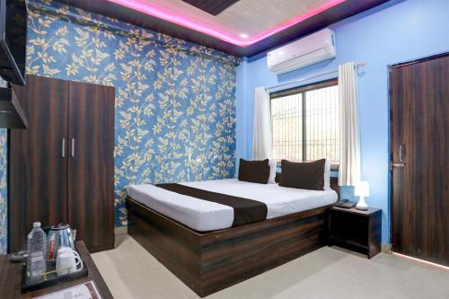 a bedroom with a bed with blue walls and a window at Hotel O by OYO Shree Paying Guest House in Varanasi