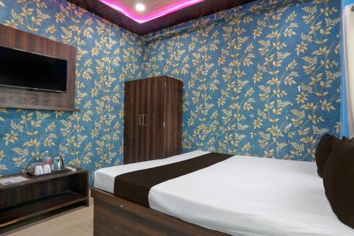 a bedroom with a bed with blue floral wallpaper at Hotel O by OYO Shree Paying Guest House in Varanasi