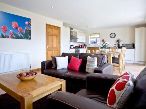 a living room with a couch and a table at Cedar Lodge - Retallack in Saint Columb Major