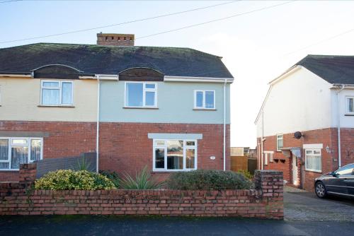a house with a brick fence in front of it at Seymour House in Exmouth