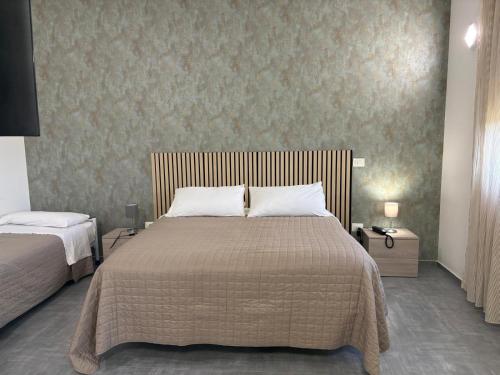 a bedroom with a large bed and two night stands at Hotel Bastione in Brindisi