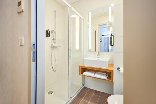 a bathroom with a shower and a sink at ibis De Haan in De Haan