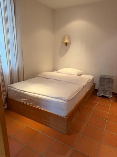 a bed in a small room with a white mattress at Scheune B7 in Düsseldorf