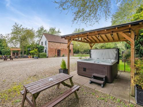 a barbecue under a pavilion with a picnic table at The Hayloft - 17238 in York